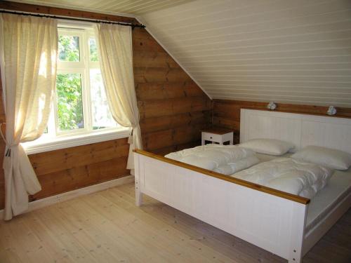 a bedroom with a bed in a room with a window at "Butikken" - sea cabins in Ulvik
