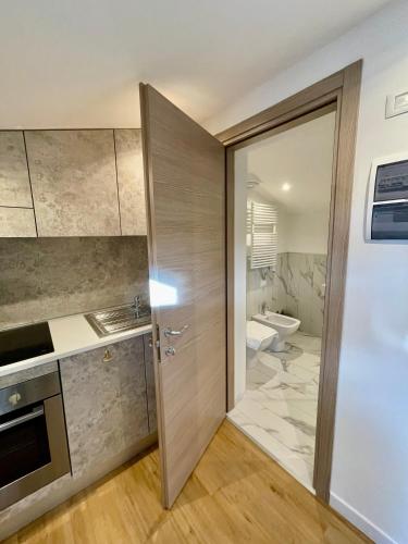 ein Bad mit einer Tür, die in ein Bad mit einem WC führt in der Unterkunft Mascheretta Affittacamere in Dolo