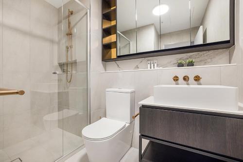 La salle de bains est pourvue de toilettes, d'un lavabo et d'une douche. dans l'établissement Stay Near Botanic Garden with Gym, Sauna & Parking, à Melbourne