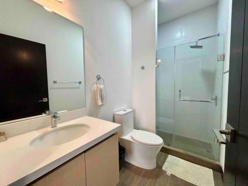 a bathroom with a toilet and a sink and a shower at New Modern Apartment with pool in Guatemala