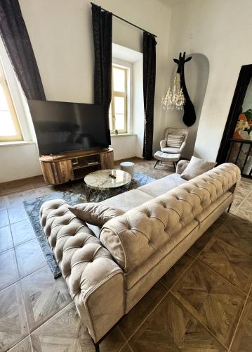 a living room with a couch and a flat screen tv at Opera apartments in Banská Štiavnica