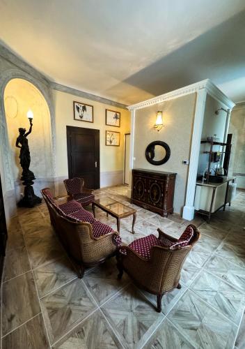 a living room with chairs and a table and a statue at Opera apartments in Banská Štiavnica
