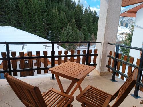 a wooden table and two chairs on a balcony at Villa Victoria in Stoykite