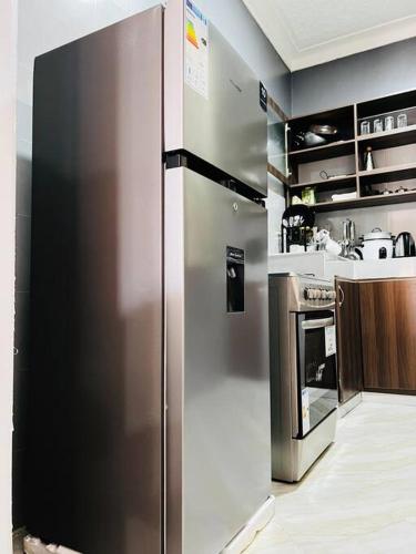 duża lodówka ze stali nierdzewnej w kuchni w obiekcie Malaika Homes Jinja w mieście Jinja
