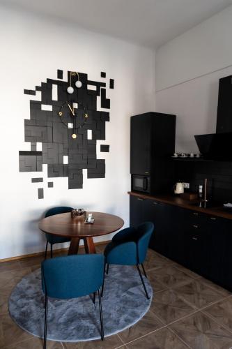 a dining room with a table and blue chairs at Opera apartments in Banská Štiavnica