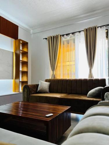 een woonkamer met een bank en een salontafel bij Malaika Homes Jinja in Jinja