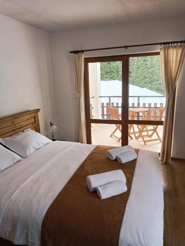 a bedroom with a bed with two towels on it at Villa Victoria in Stoykite