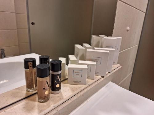 a bathroom counter with products on a sink at Duna Garden Hotel in Budapest