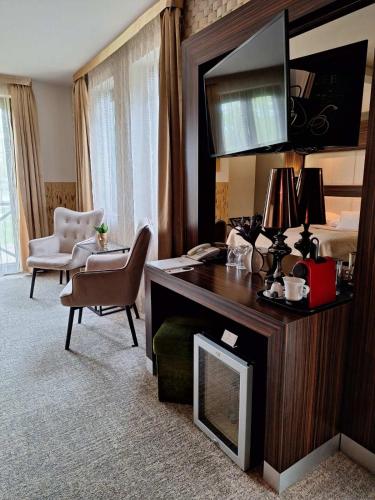 a hotel room with a desk and a bedroom at Duna Garden Hotel in Budapest