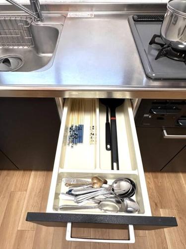 a drawer in a kitchen with utensils under a counter at Kyo Sai 浅草2F浅草寺まで徒步約10分 in Tokyo