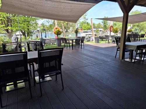 an outdoor deck with tables and chairs and umbrellas at Duna Garden Hotel in Budapest