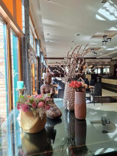 a lobby with two vases with flowers on a table at Duna Garden Hotel in Budapest