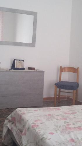 a bedroom with a bed and a chair and a mirror at Da Anto in Trivio