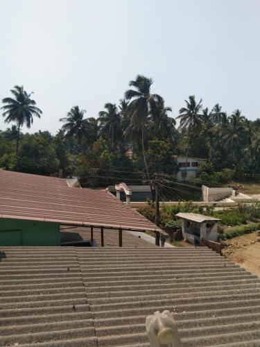a view of a building with palm trees in the background at Advait Holiday Home in Nagaon