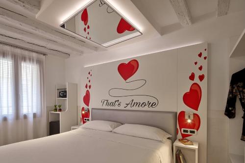 a bedroom with a bed with hearts on the wall at UNAHOTELS Ala Venezia-Adults 16 in Venice