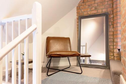 a brown chair sitting in front of a mirror at Chapel View in Loughborough