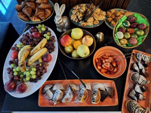 a table topped with bowls of different types of food at Duna Garden Hotel in Budapest