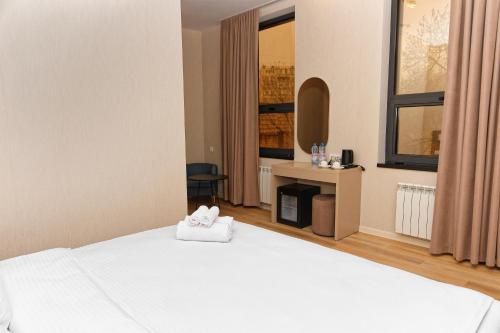 a bedroom with a bed with two towels on it at Aston Hotel in Aktau