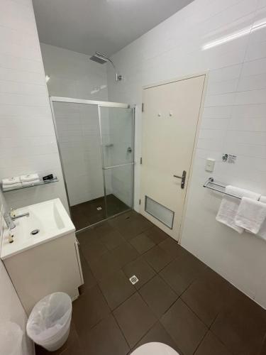 a bathroom with a shower and a toilet and a sink at Sfera's Park Suites & Convention Centre in Adelaide