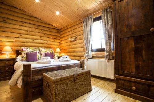 a bedroom with a bed in a log cabin at Gingerbread Log Cabin in Eshott