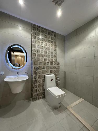 a bathroom with a toilet and a sink and a mirror at شقق جيهان الخاصة in Al Madinah