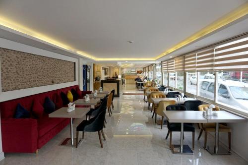 a restaurant with tables and chairs and a red couch at Mandalin Otel in Antalya