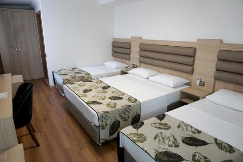 a room with three beds in a room at Mandalin Otel in Antalya