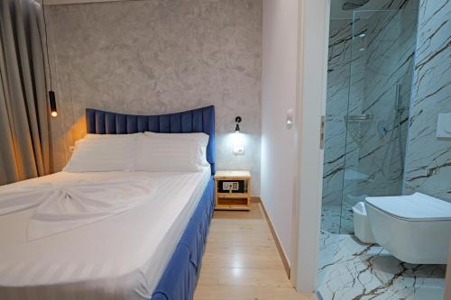 a bedroom with a bed and a shower and a toilet at Villa Juna Beach in Sarandë