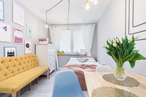 a bedroom with a bed and a table with a vase of flowers at CozyApartment in Centre of Gdańsk! in Gdańsk
