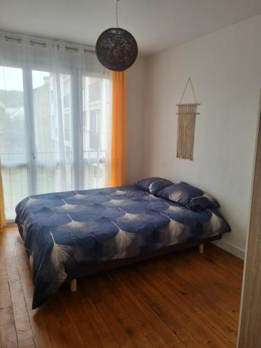 a bedroom with a bed with a blue comforter at 5 pièces traversant proche paris in Poissy