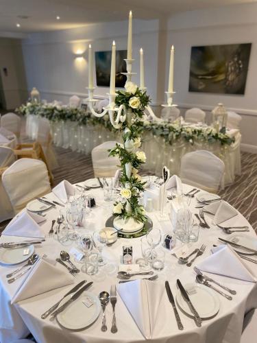a table with white table cloths and a centerpiece with candles at Lion Hotel in Worksop