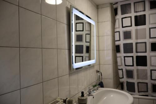 a bathroom with a sink and a mirror at Hirsch24- 4 Personen Apartment in Lippstadt