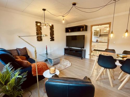 a living room with a couch and a table at Lot54 Deluxe Apartements in Neidenbach
