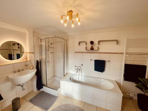 y baño con bañera, lavamanos y ducha. en Lot54 Deluxe Apartements, en Neidenbach