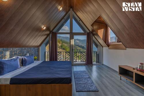 a bedroom with a bed and a large window at StayVista at Orion Villa in Shimla