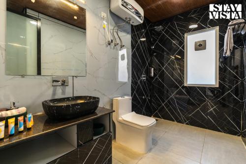 La salle de bains est pourvue d'un lavabo et de toilettes. dans l'établissement StayVista at Orion Villa, à Shimla