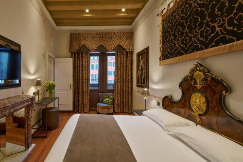 a bedroom with a large bed and a television at UNAHOTELS Ala Venezia-Adults 16 in Venice