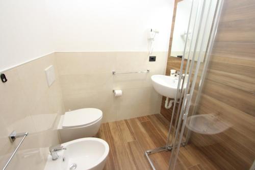 een badkamer met een toilet, een wastafel en een douche bij Hotel Laura in Bibione