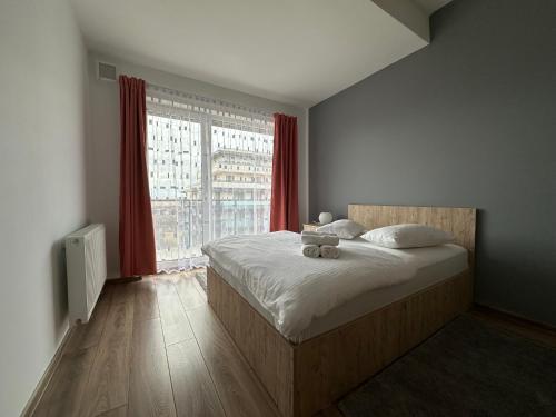 - une chambre avec un lit et une grande fenêtre dans l'établissement Grand Park Green Iulius Mall, à Cluj-Napoca