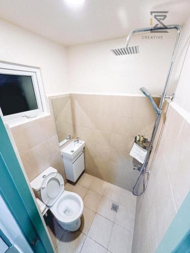 a small bathroom with a toilet and a window at CreativeSpace-Mactan2 in Lapu Lapu City