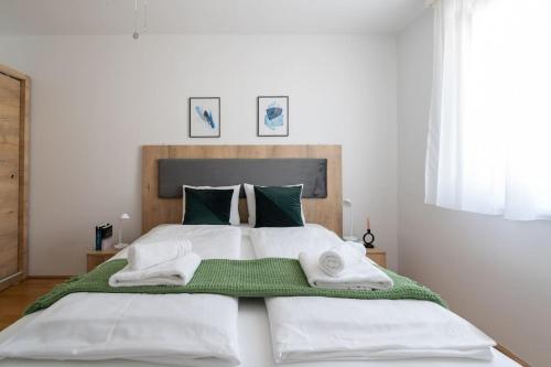 een slaapkamer met een groot bed en handdoeken bij HM • Trendy 1BR, Direct City Access in Wenen