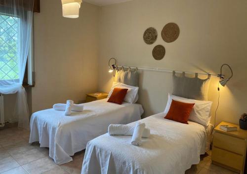 1 dormitorio con 2 camas con sábanas blancas en Oppeano - La Casa sulla Rionda, en Oppeano