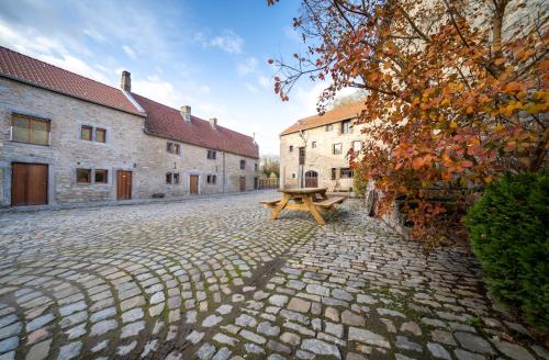 a wooden picnic table sitting on a cobblestone street at Le Grenier du Moulin in Héron