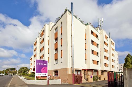 a white building with a sign in front of it at Cerise Nantes La Beaujoire in Nantes