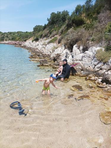 a man and a child playing in the water on a beach at Villa Fraoulitsa in Skoutarion