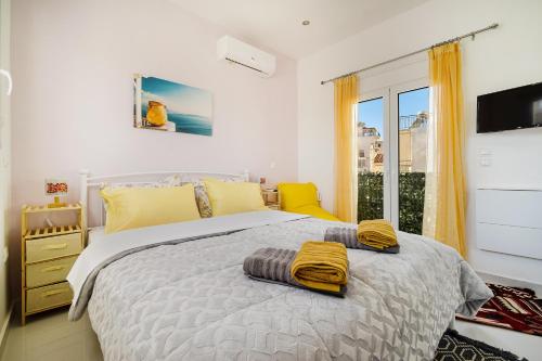 a bedroom with a bed with yellow towels on it at Posh hood Rooftop with balconies in Athens