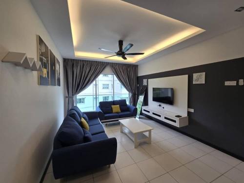 a living room with a blue couch and a tv at D'Gaya Homestay Quintet Cameron Highlands in Tanah Rata