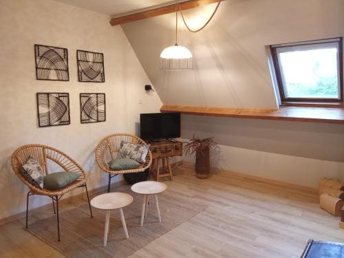 uma sala de estar com duas cadeiras e uma televisão em Chambres d'Hôtes Ailes et Iles em Pleudaniel