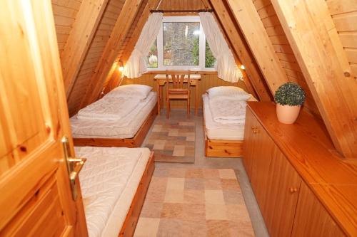 ダンプにあるZeltdachhaus _ grosse Terrasse _ mのベッド2台とテーブルが備わる小さな客室です。