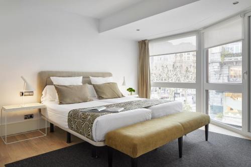ein Schlafzimmer mit einem großen Bett und einem großen Fenster in der Unterkunft Koxtape Apartment by FeelFree Rentals in San Sebastián